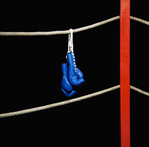 Boxing gloves hanging from boxing ring